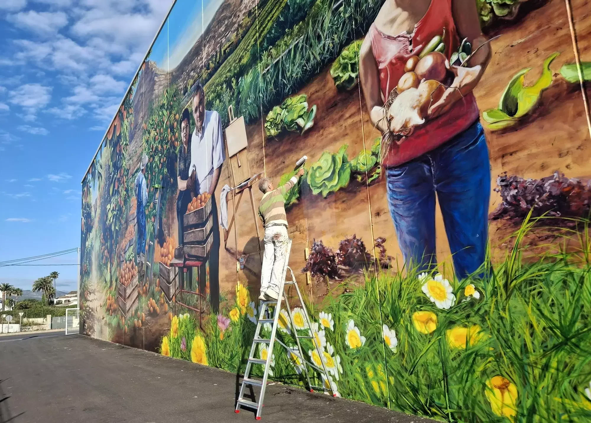 Paisaje, esencia y familia: un colosal y precioso mural redime una pared de hormigón de una nave comercial en Xàbia